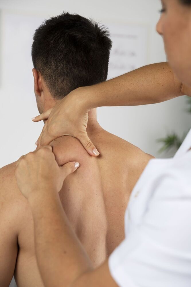 physiotherapist-performing-therapeutic-massage-male-client (1)